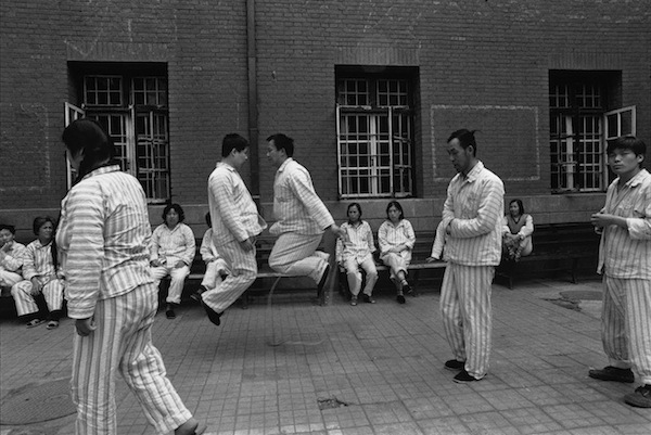 Les activités de plein air sont limitées dans ce centre psychiatrique de Pékin. Les patients se promènent, s’assoient, et certains s’amusent à sauter. ©Lu-Nan / Magnum Photos 